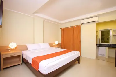 a bedroom with a large bed and a television at The Platinum Suites Bangkok by Dancenter in Bangkok