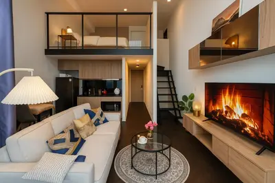 a living room with a couch and a fireplace at Luxury Loft with Stunning 25th Floor View in Bangkok