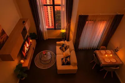 a living room with a couch and a table and a window at Luxury Loft with Stunning 25th Floor View in Bangkok