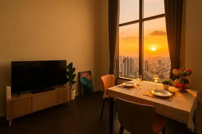 a living room with a table with a television and a window at Luxury Loft with Stunning 25th Floor View in Bangkok