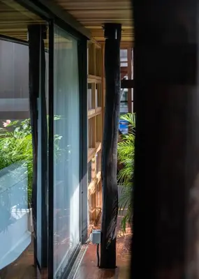 a room with a glass door and some plants at Vanich House - Mechanic's Room in Bangkok