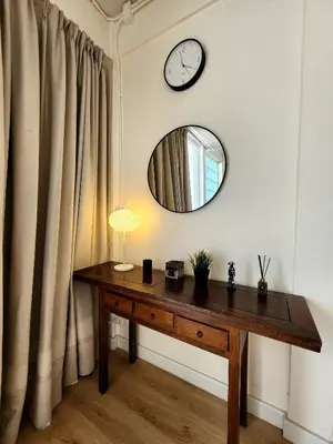a table with a mirror and a clock on a wall at Cozy Bangkok Townhouse for 7 Guests, 5-Minute Walk from BTS in Amphoe Phra Khanong