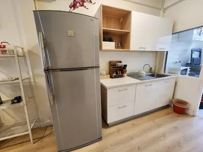 a stainless steel refrigerator in a kitchen with white cabinets at Cozy Bangkok Townhouse for 7 Guests, 5-Minute Walk from BTS in Amphoe Phra Khanong