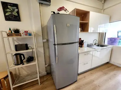 a stainless steel refrigerator in a kitchen with white cabinets at Cozy Bangkok Townhouse for 7 Guests, 5-Minute Walk from BTS in Amphoe Phra Khanong
