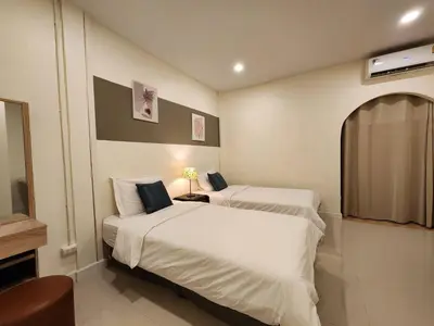 a hotel room with two beds and a television at Cozy Bangkok Townhouse for 7 Guests, 5-Minute Walk from BTS in Amphoe Phra Khanong