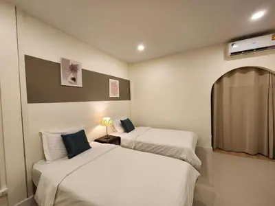 a bedroom with two beds and a window at Cozy Bangkok Townhouse for 7 Guests, 5-Minute Walk from BTS in Amphoe Phra Khanong