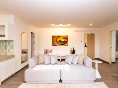 a living room with a white couch and a table at 2 Bedrooms for 4 Guests with Terrace in the Heart of Sathorn in Bangkok