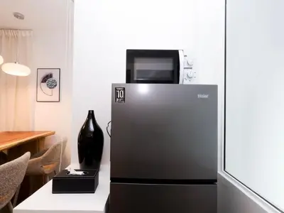 a refrigerator with a microwave on top of it at 2 Bedrooms for 4 Guests with Terrace in the Heart of Sathorn in Bangkok