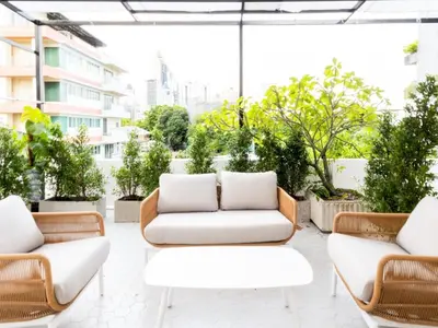 a patio with two white couches and some plants at 2 Bedrooms for 4 Guests with Terrace in the Heart of Sathorn in Bangkok