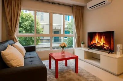 a living room with a couch and a fireplace at Cozy City Retreat in Ekkamai in Bangkok