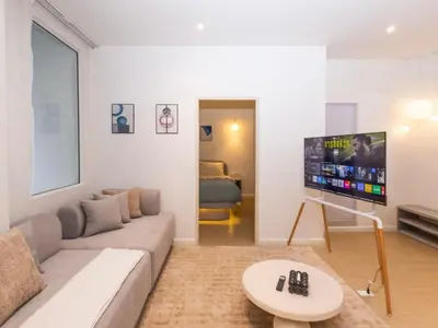a living room with a couch and a flat screen tv at 2 Bedrooms for 4 Guests with Kitchen at Heart of Sathorn in Bangkok