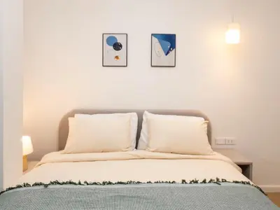 a bedroom with a bed with three pictures on the wall at 2 Bedrooms for 4 Guests with Kitchen at Heart of Sathorn in Bangkok