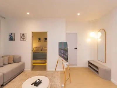 a living room with a couch and a flat screen tv at 2 Bedrooms for 4 Guests with Kitchen at Heart of Sathorn in Bangkok