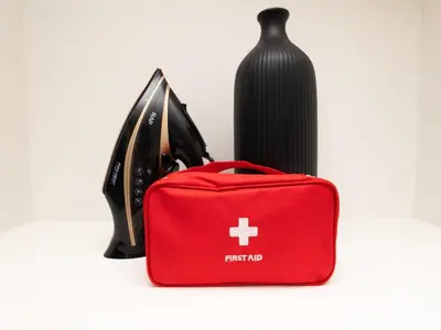 a red suitcase next to a vase and a bottle at 3 Bedrooms for 5 Guests in the Heart of Sathorn in Bangkok
