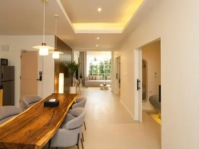 a kitchen and living room with a wooden table and chairs at 3 Bedrooms for 5 Guests in the Heart of Sathorn in Bangkok