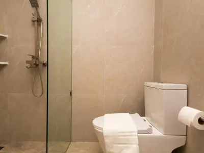 a bathroom with a toilet and a glass shower at Lovely Studio Room for 2 Guests in the Heart of Sathorn in Bangkok