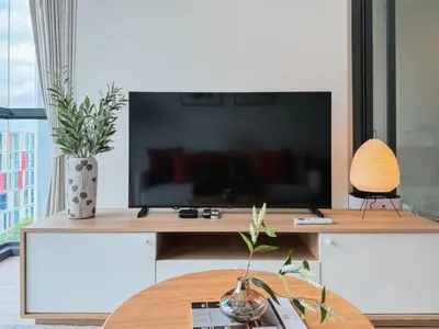a living room with a large television on a table at Near BTS l Workspace and Kitchen - Pool and Gym l Sontana in Bangkok