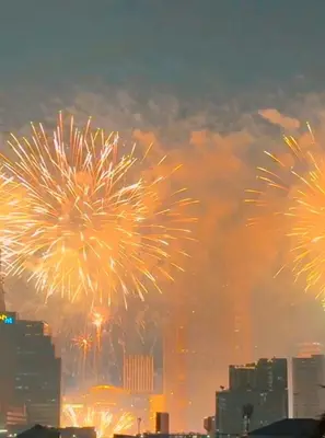 a group of fireworks exploding in the sky over a city at Aura Hostel in Bangkok