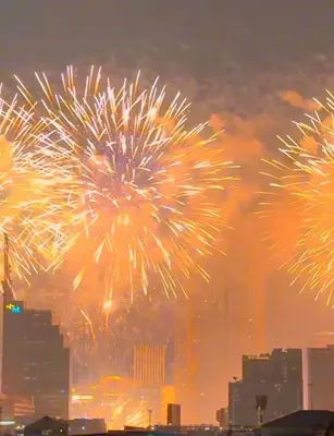 a group of fireworks exploding in the sky over a city at Aura Hostel in Bangkok