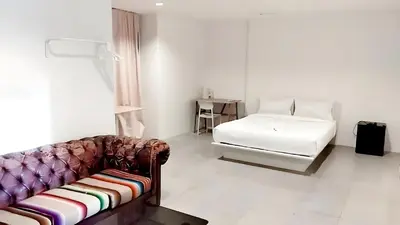 a living room with a couch and a bed at x Mirt Inn Sukhumvit II - ถนนสุขุมวิท 2 in Bang Kapi