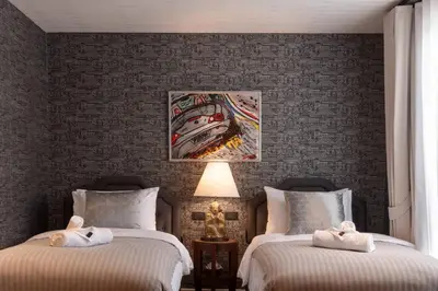 a bedroom with two beds and a painting on the wall at Presidential Suite | 5 min BTS, Sun-Room| 159sqm in Khlong Toei