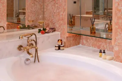 a white bath tub with a gold faucet at Presidential Suite | 5 min BTS, Sun-Room| 159sqm in Khlong Toei