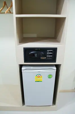 a small refrigerator in a shelf with a microwave at La Porte Hotel Bangkok in Bangkok