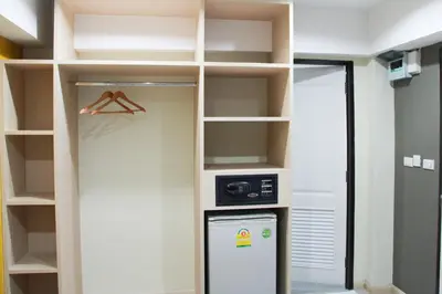 a walk in closet with a microwave and a refrigerator at La Porte Hotel Bangkok in Bangkok