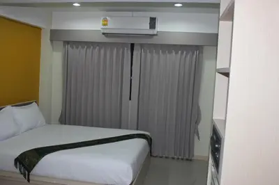 a hotel room with a bed and a air conditioner at La Porte Hotel Bangkok in Bangkok