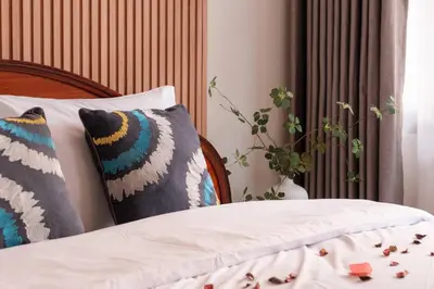 a bedroom with a bed with pillows on it at ThongLor|Spacious 4BR4BA, Fast-WiFi, Netflix, Shop in Khlong Toei