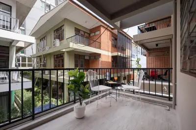 a balcony of a building with chairs and a plant at ThongLor|Spacious 4BR4BA, Fast-WiFi, Netflix, Shop in Khlong Toei