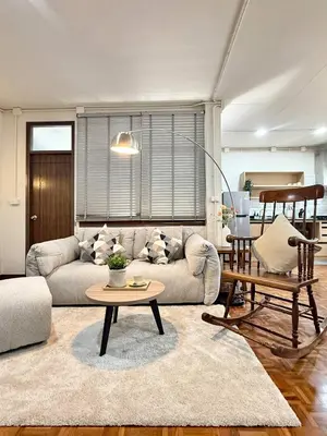 a living room with a couch and a table at Spacious CityCentre | 500 mbps, King-size, Balcony in Khlong Toei
