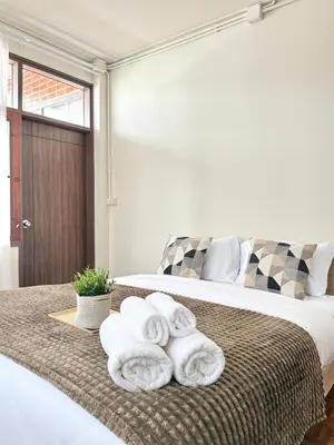 a bedroom with a bed with towels on it at Spacious CityCentre | 500 mbps, King-size, Balcony in Khlong Toei