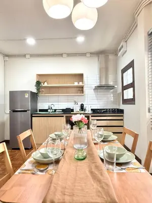 a kitchen with a wooden table with wine glasses at Spacious CityCentre | 500 mbps, King-size, Balcony in Khlong Toei