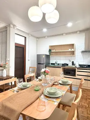 a dining room with a wooden table and chairs at Spacious CityCentre | 500 mbps, King-size, Balcony in Khlong Toei