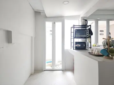 a kitchen with a counter with a microwave and a window at White House Ekkamai in Bangkok