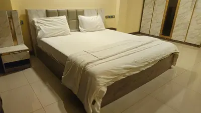 a bed with white sheets and pillows in a room at indra apartments in Bangkok