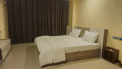 a bedroom with a bed with white sheets and pillows at indra apartments in Bangkok