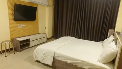 a hotel room with a bed and a flat screen tv at indra apartments in Bangkok