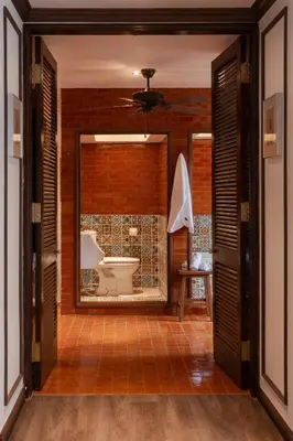 a bathroom with a toilet and a brick wall at Contemporary Eastern 1BR 5 min BTS| All Essential in Khlong Toei