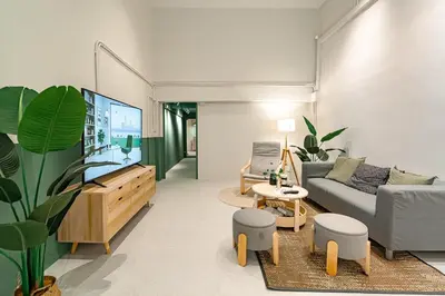 a living room with a couch and a flat screen tv at Cozy 3BR for 8 People, 5Mins from MRT Huai Khwang in Bangkok