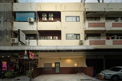 a tall building with cars parked in front of it at Cozy 3BR for 8 People, 5Mins from MRT Huai Khwang in Bangkok