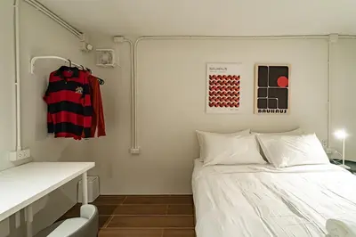 a small room with a bed and a desk at Cozy 3BR for 8 People, 5Mins from MRT Huai Khwang in Bangkok