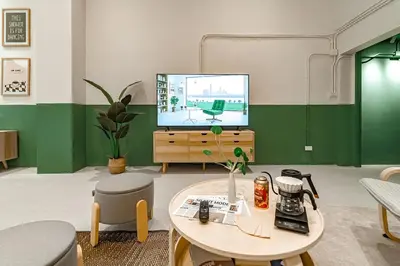 a living room with a tv and a table and a coffee table at Cozy 3BR for 8 People, 5Mins from MRT Huai Khwang in Bangkok