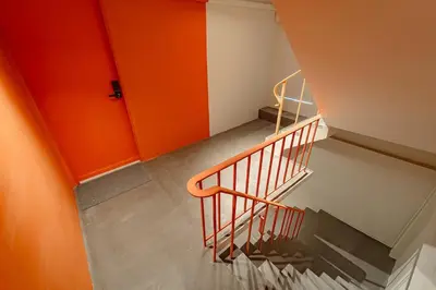 a staircase with orange walls and a stair railing at 2BR APT on 2nd floor for 6 ppl in Bangkok