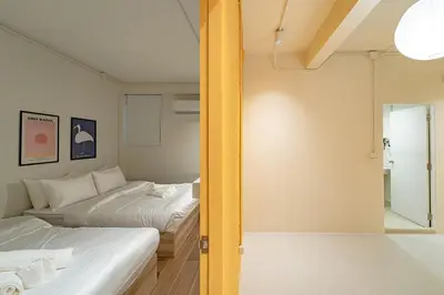 two beds in a small room with a mirror at A 3BR apartment for 8 pax on 3Floor in Bangkok