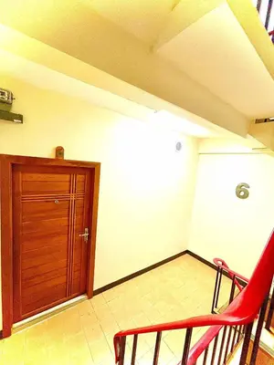 a room with a wooden door and a red chair at The Little Apartment in Bangkok