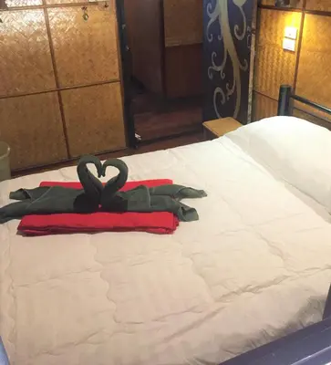 a bed with a pair of gloves on it at Shanti Lodge Bangkok in Bangkok