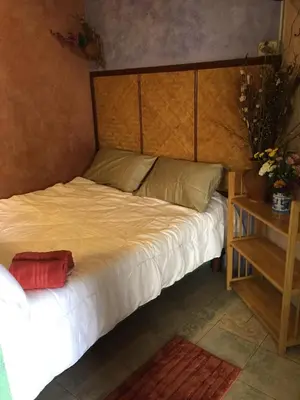 a bed with a wooden headboard in a room at Shanti Lodge Bangkok in Bangkok