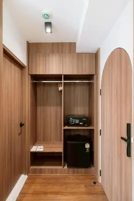 a small kitchen with wooden cabinets and a door at กรุงไทย โฮสเทล สเตชั่น in Thonhuri